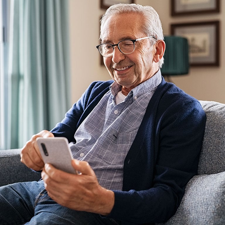 A smiling senior man using a phone 