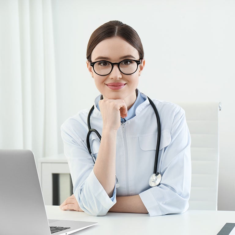 Young doctor in her office smiles into the camera