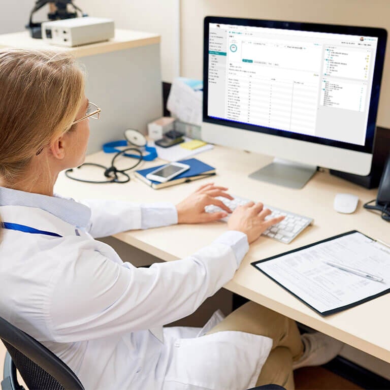 a doctor typing on a computer in her office