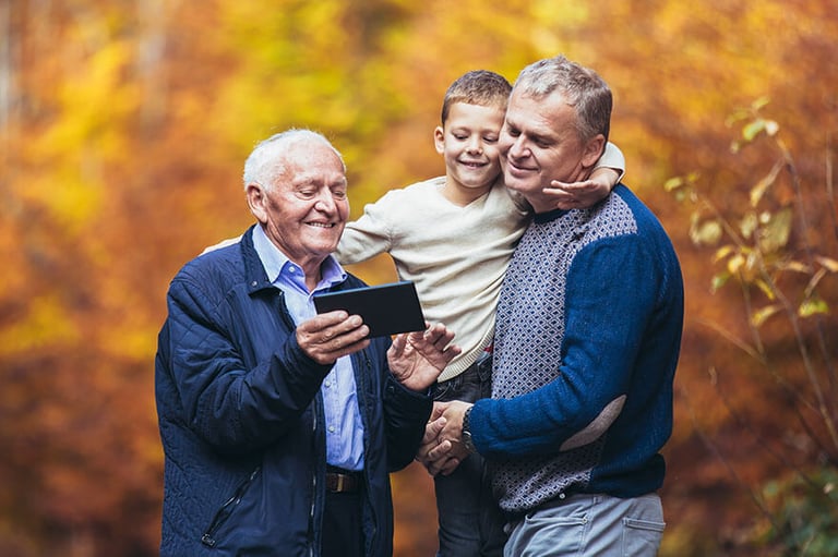 grandfather showing phone to family
