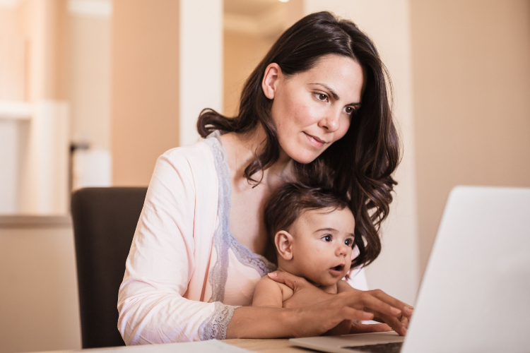 Mom holding baby at computer